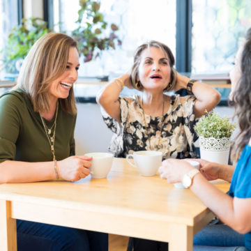 Kolme naista keskustelee kahvin ääressä.